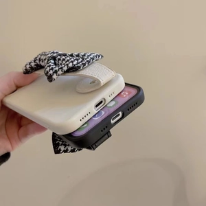 Detail of vintage houndstooth fabric bow handle on iPhone case for better grip