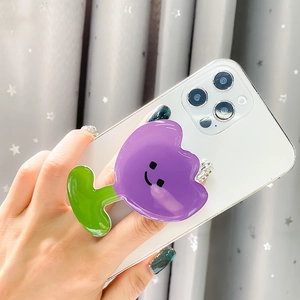 Detail of purple tulip phone grip with smiley face on a white smartphone