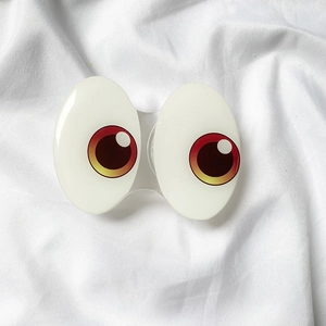 Detailed view of creative cartoon big eye phone pop socket on white fabric background