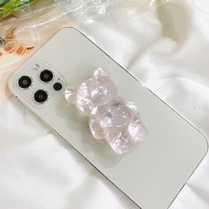 Close-up of a pink translucent bear phone socket with shell texture on a white phone