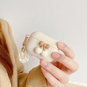 Close-up of cream silicone AirPods Pro case with 3D bow and shell charm details