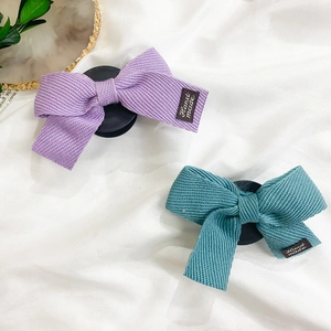 Gros plan de barrettes à nœuds faits main avec texture côtelée et étiquette tissée