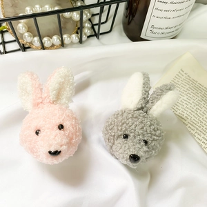 Detail of cute plush bunny head accessories in pink and grey for hair or phone decoration