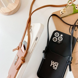 Detail of crossbody leather phone case with detachable wallet card holder and rhinestone logo