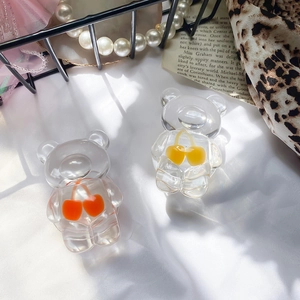 Detailed shot of cute transparent bear-shaped phone grips with cherry motifs on vintage book