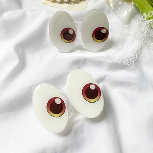 Close-up of cute cartoon big eyes hair clips on elegant white aesthetic lace background