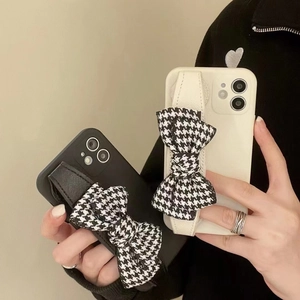 iPhone case with wrist strap and houndstooth bowknot decoration in black and white colors