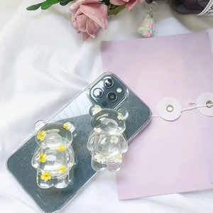 Detailed view of transparent bear phone grips with real dried flowers on a phone case