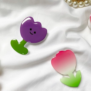 Macro detail of tulip flower phone grip featuring a glossy acrylic finish and smiley face
