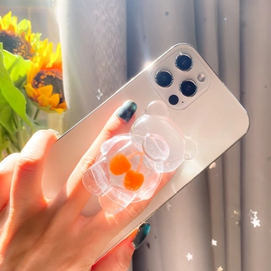 Detailed view of 3D transparent cartoon bear phone grip with cherry design on a white phone