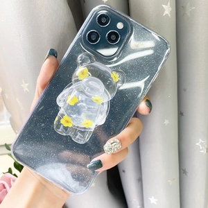 Detail of transparent bear phone socket with yellow dried flowers on glitter case