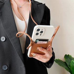 Detail view of iPhone case with white frame, brown leather card wallet and shoulder strap