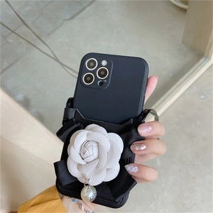 Elegant black iPhone case with 3D white camellia flower, bow, and pearl charm