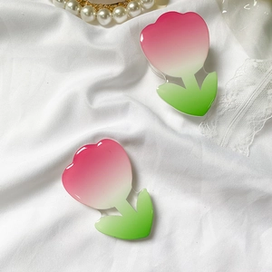 Close-up of tulip flower phone grip on white lace fabric with pearls
