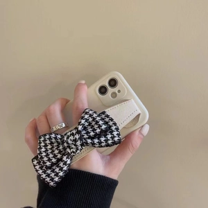 Wristband phone case with black and white houndstooth bow for iPhone 16