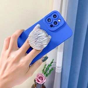 Silver metal water ripple phone grip on a dark blue matte phone case held by hand