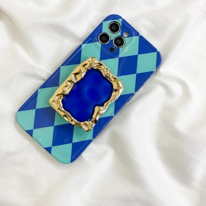 Detail of blue checkerboard iPhone case with baroque gold embossed metal phone socket