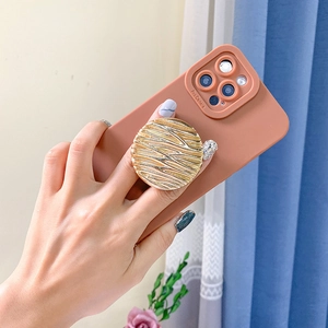 Detailed view of golden water ripple phone grip with rhinestone on matte red case