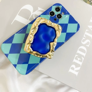 Detail of retro gold embossed frame phone grip on blue and green checkered case
