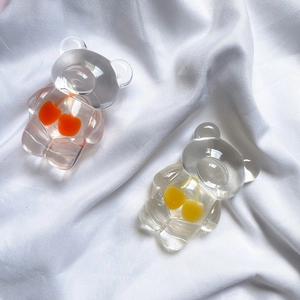 Close-up of cute transparent resin bears with cherry inserts on white fabric
