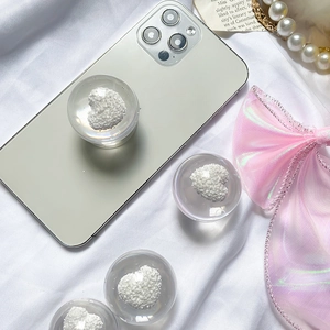 Minimalist clear crystal ball phone grip with white heart pattern on phone back