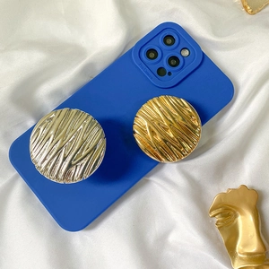 Blue iPhone Pro case with two metal wave pattern pop sockets on white fabric