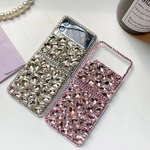 Close-up of luxury rhinestone-encrusted cases for foldable phones in silver and pink