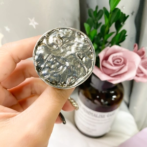 Detailed view of silver plated metal ring with hammer textured finish on finger