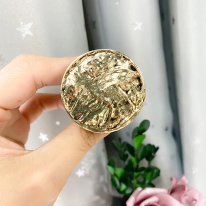 Macro shot of a vintage style round gold metallic phone socket grip with relief details