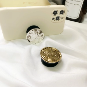 Detail of vintage metallic hammered texture phone socket grip in gold and silver