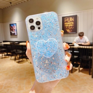 Funda de iPhone con purpurina azul y un soporte de agarre en forma de corazón