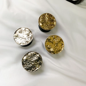 Detail of four metallic round phone grip stands with vintage textured hammer pattern finish