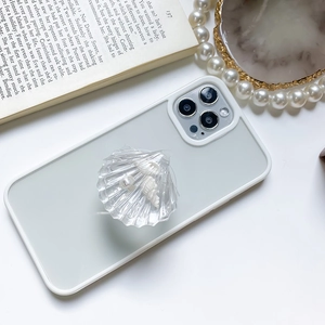 Detailed view of white smartphone case featuring a clear 3D shell grip and pearl accessories