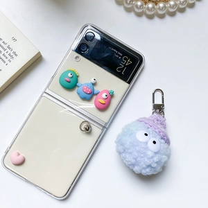 Close-up of transparent phone case featuring 3D cartoon monsters and plush charm for Galaxy Z Flip