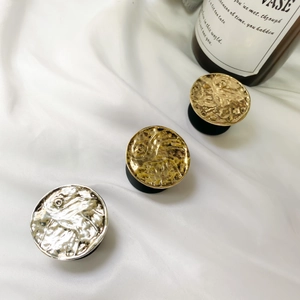 Three circular metallic phone sockets with retro ripple texture on white silk fabric