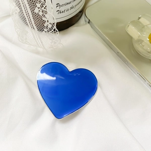Detail view of heart-shaped Klein blue phone grip with shiny silver metal edges
