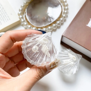 Detail of transparent shell phone grip with embedded pearls and seashells decor