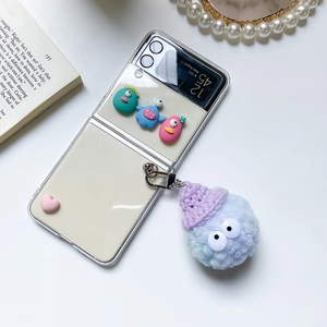 Detail of Galaxy Z Flip case with cute cartoon monsters and blue plush ball charm