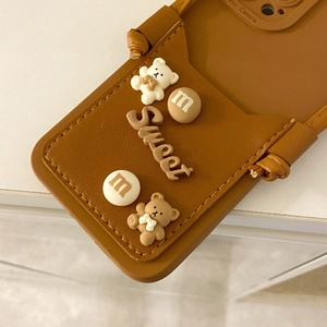Dettaglio custodia in pelle marrone con ciondoli orsetto 3D e decorazioni cioccolato