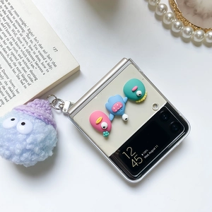 Samsung Z Flip case detail showing 3D cartoon figures and blue plush monster charm