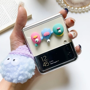 Detail of Galaxy Z Flip clear case with 3D cartoon monsters and a large plush pompom charm