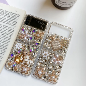 Detail of luxury rhinestone teddy bear and pearl ornaments on a folding phone case