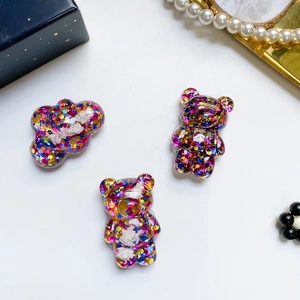 Dettaglio supporto telefono orso e nuvola in resina con paillettes multicolore