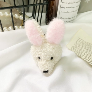 Support de téléphone lapin en peluche blanche aux oreilles roses sur tissu doux