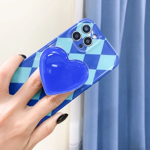 Blue heart-shaped folding phone grip on a stylish checkerboard patterned phone case