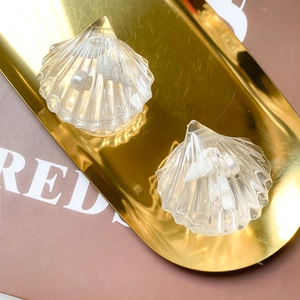Transparent shell phone grip with pearl inlay on a luxury gold display tray