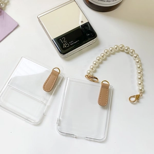 Detailed view of clear Galaxy Z Flip case with pearl strap and brown leather loop
