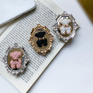 Detail of vintage bear phone grips with baroque frames and quilted texture surfaces