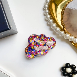 Dettaglio del supporto per telefono a nuvola con paillettes colorate e glitter