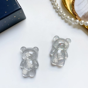 Close-up of glitter resin bear phone grip with sparkling silver sequins and white clouds